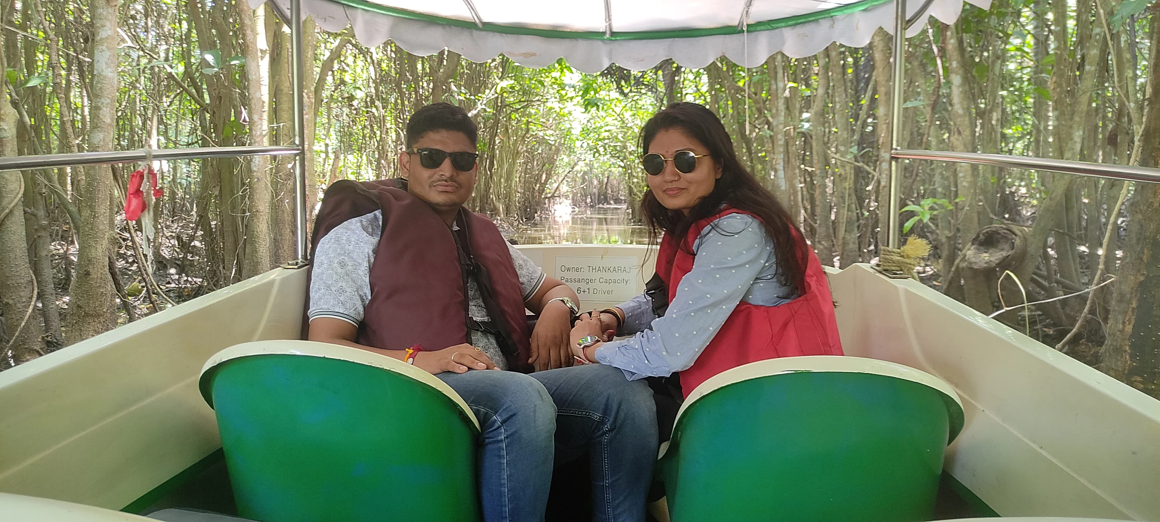 Traditional Kerala houseboat cruising through Poovar backwaters with mangrove forests and golden beach views