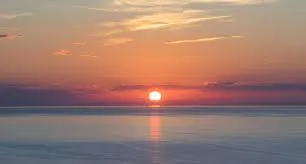 Sunset cruise in Poovar backwaters showing golden sky reflecting on water